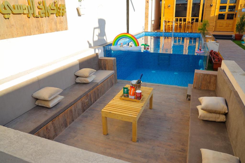 a table sitting on a patio next to a swimming pool at أكواخ الردسي in Jeddah