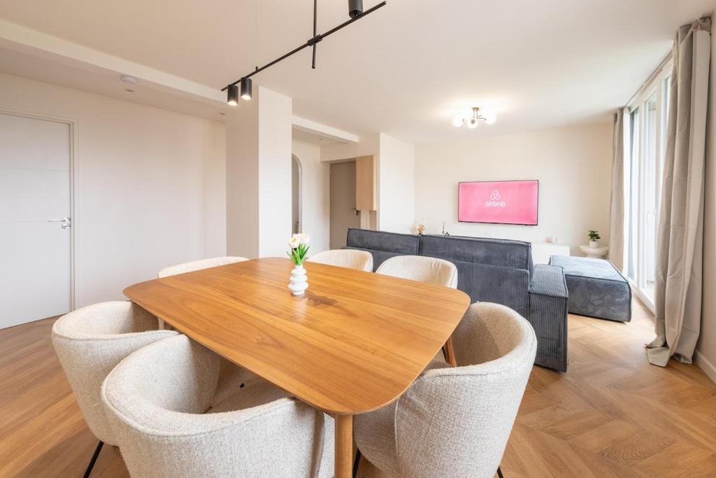Un comedor con mesa y sillas de madera. en Mat&Ness Luxury, en Beauvais