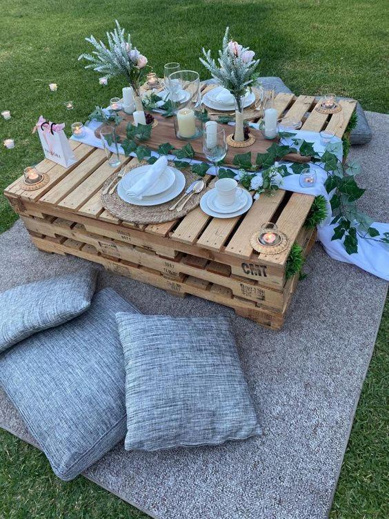 a wooden table with plates and candles on top at Kolobeng Cottages in Gaborone