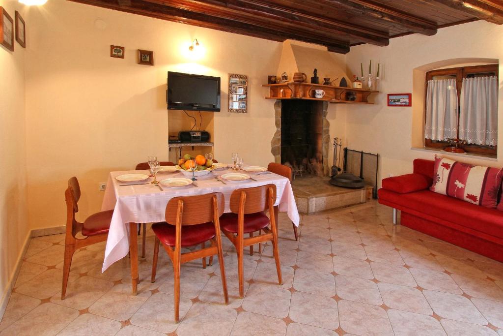 a dining room with a table and a red couch at Holiday Home Marko Funtana in Funtana