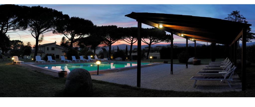 una piscina con sillas y un pabellón por la noche en Capracotta, en Montemassi