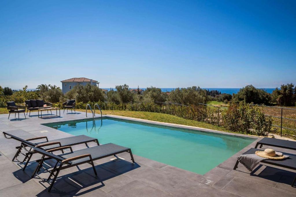 a swimming pool with two lounge chairs at Chrysa by Vintage Travel in Lakithra