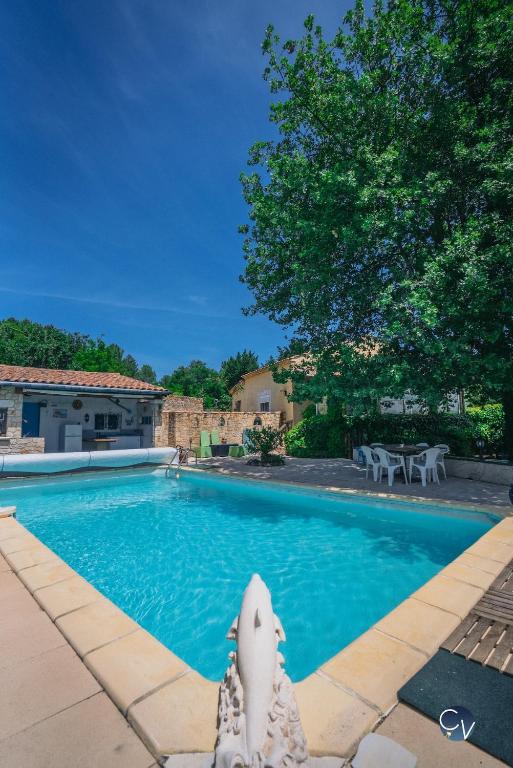 une piscine avec une statue de requin au milieu dans l'établissement Villa avec piscine et studio, Séjour convivial !, à Sabran