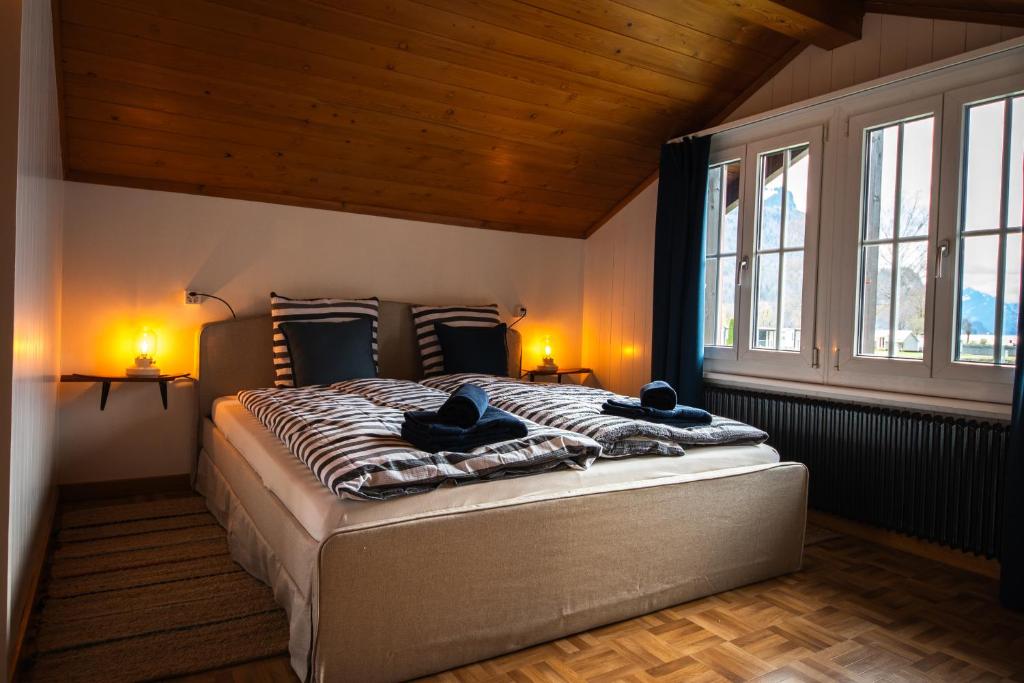 una camera con un grande letto in una stanza con finestre di Beachhouse 16 Brienzersee a Brienz