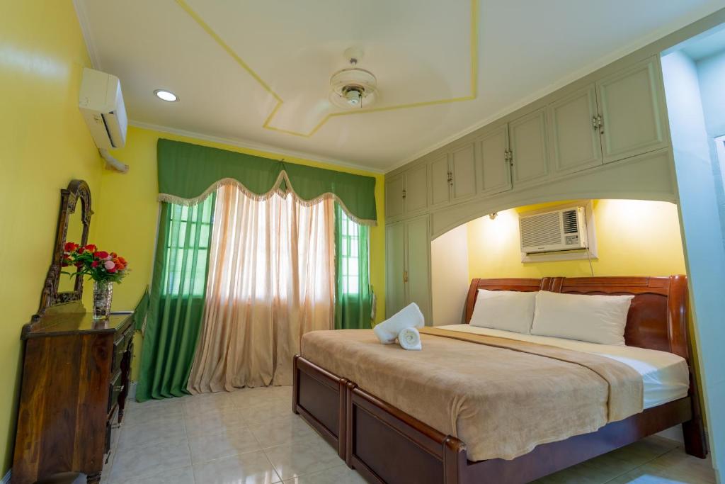 a bedroom with a large bed and a window at Panglao villa family reunions in Panglao