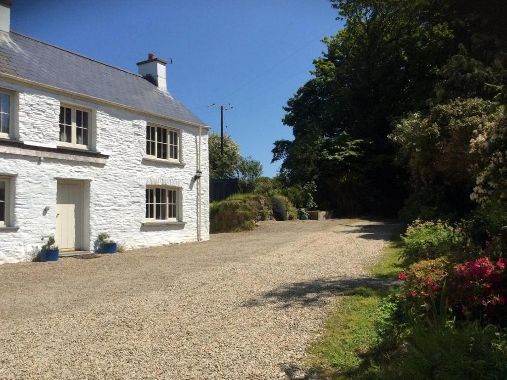 a white stone house with a gravel driveway at Bayvil - Nevern in Velindre-farchog