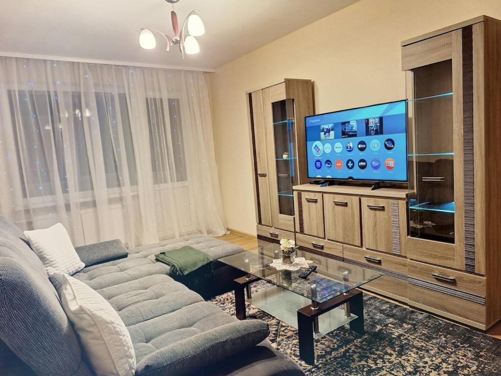 a living room with a couch and a flat screen tv at Emvika Tauragė apartment in Tauragė