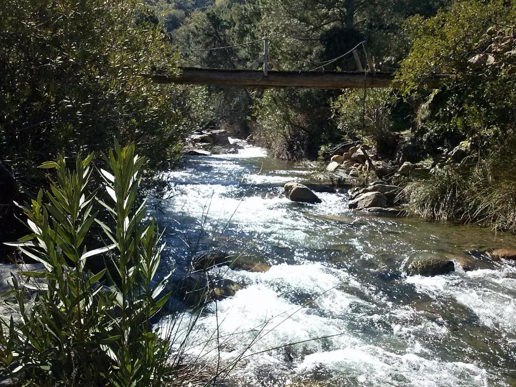 a river with a bridge in the middle of it at La Posada del Recovero in Genalguacil