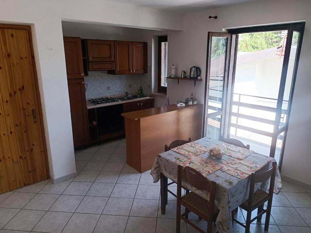 a kitchen with a table and a kitchen with a table and chairs at Home Friends in Camigliatello Silano