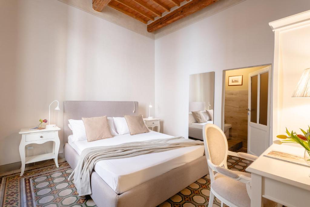 a white bedroom with a bed and a desk at San Martino Suite in Pisa
