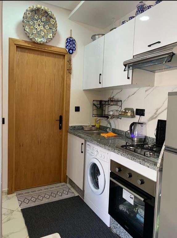 a kitchen with a washing machine and a washer at Hay al qods in Casablanca