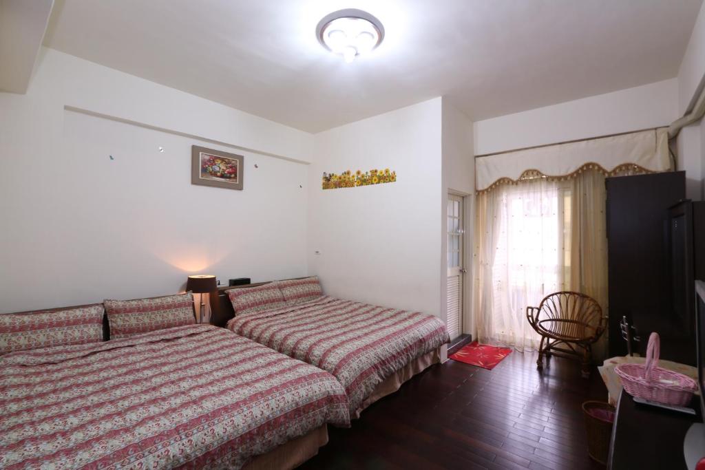 a bedroom with a bed and a chair and a window at Fangyi Homestay in Ji'an