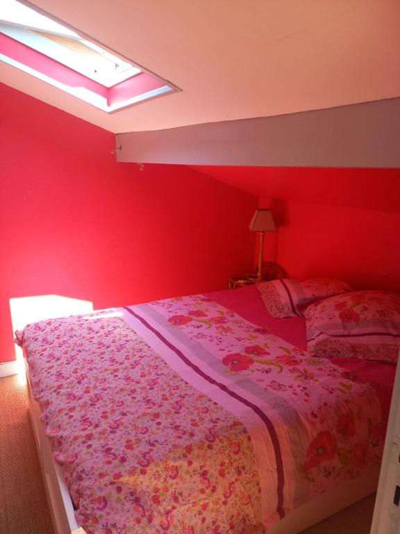 a bedroom with a bed with a red wall at Villa patio Seignosse in Seignosse