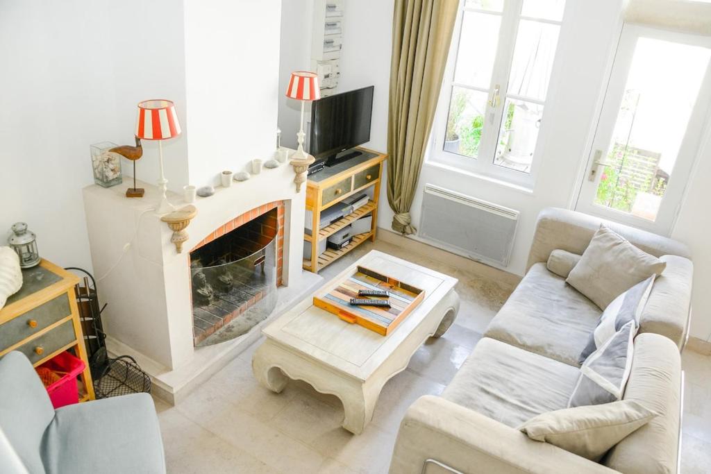 un salon avec un canapé et une cheminée dans l'établissement La Maison Bleue, à Cabourg