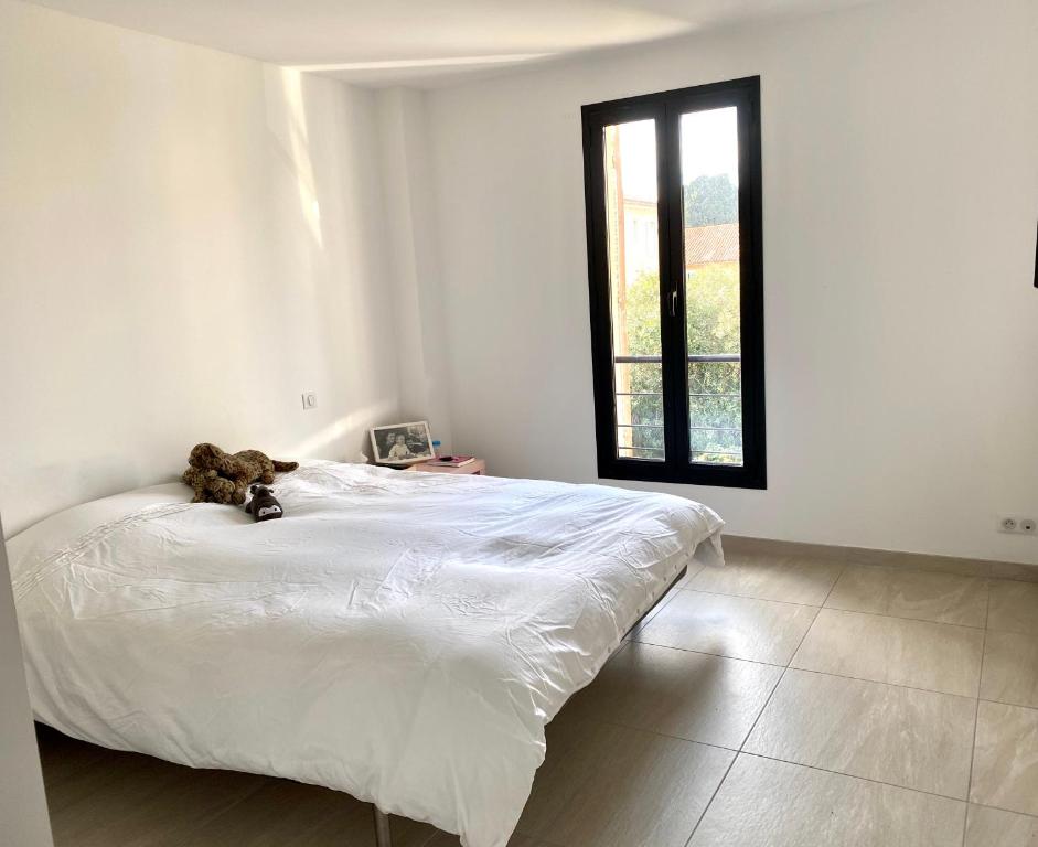 - un ours en peluche assis sur un lit dans une chambre dans l'établissement charmante maison de vacances au Mourillon, à Toulon