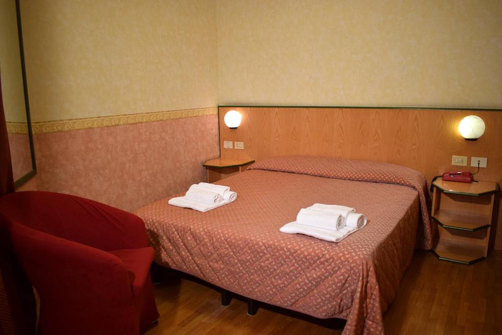 a hotel room with two beds with towels on them at Hotel Baffo Rosso in Alba Adriatica