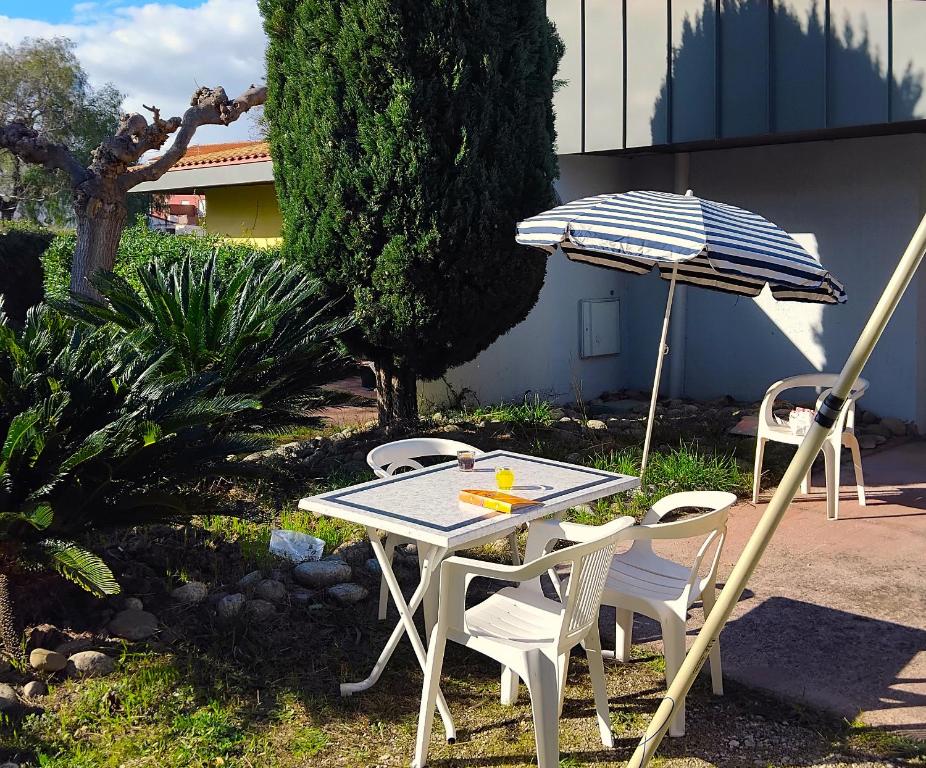 een tafel en stoelen en een parasol in de tuin bij Canopéa by ULVF in Sainte-Marie-la-Mer