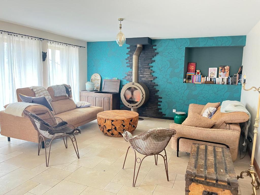 un salon avec un canapé et des chaises dans l'établissement Maison à chambois, à Gouffern en Auge