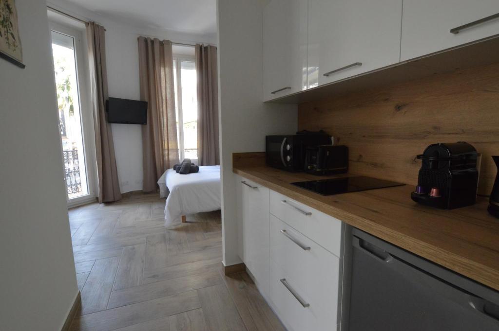 une cuisine avec des armoires blanches et un comptoir dans l'établissement Studio entre plage et centre Cannes, à Cannes
