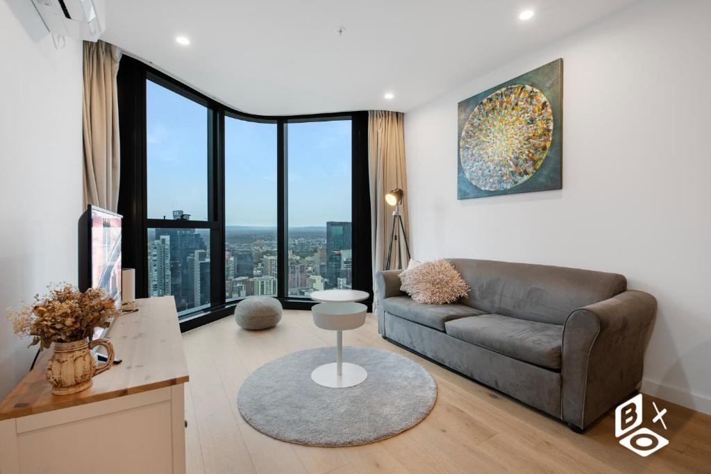 un soggiorno con un divano e una grande finestra di REST Melbourne Central Apartment a Melbourne