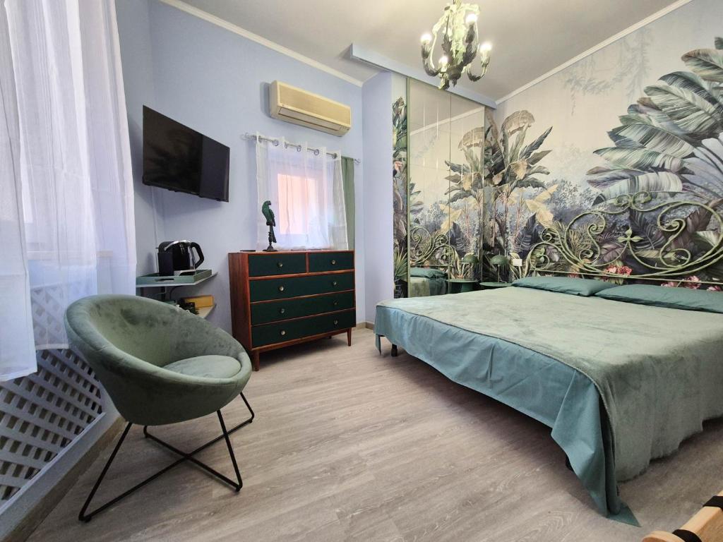 a bedroom with a green bed and a chair at La Petite Maison By Case al Lago in Desenzano del Garda
