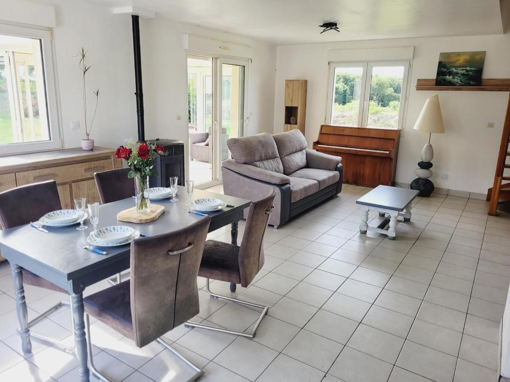 ein Wohnzimmer mit Tisch und Couch in der Unterkunft Family Home Between Land Sea Maison Familial Entre Terre et Mer Avec piscine in Plédran