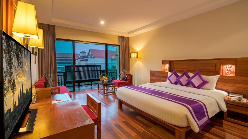 Postel nebo postele na pokoji v ubytování Angkor Miracle Resort & Spa
