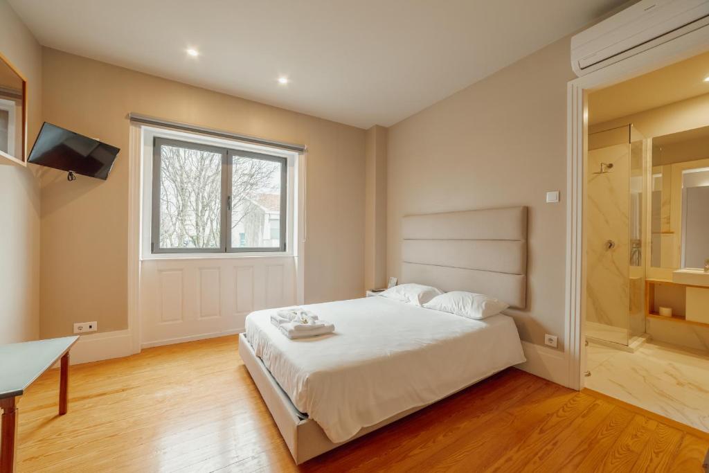 a bedroom with a large bed and a window at Boutique Suites by Hosty in Porto