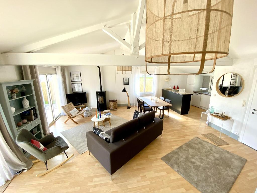 un salon avec un canapé noir et une table dans l'établissement L Oiseau, à Saint-Hilaire-de-Riez