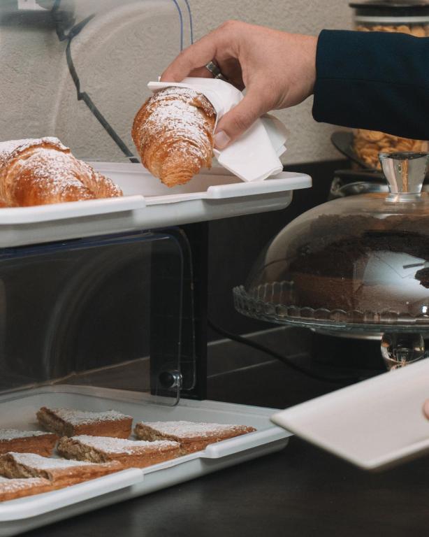 a person taking a plate of bread from an oven at TRAVEL STATION Bedandbreakfast in Bari