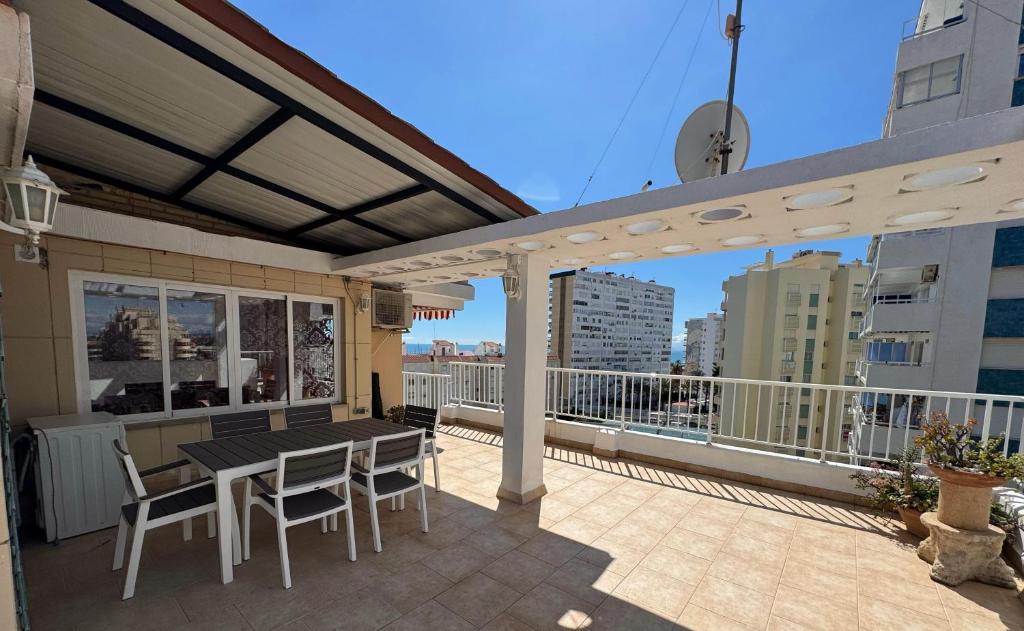 un patio avec une table et des chaises sur un balcon dans l'établissement Ático con terraza y vistas al mar, à Puebla de Farnals