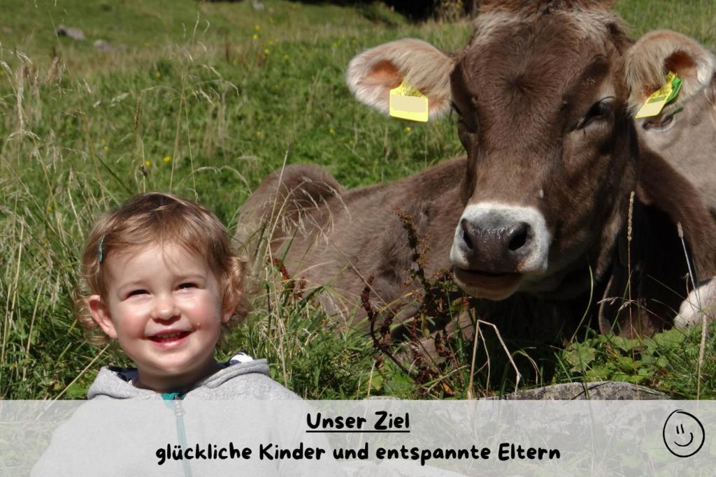 a young boy standing in front of a cow at Ferienhof Matthias Herz in Rettenberg
