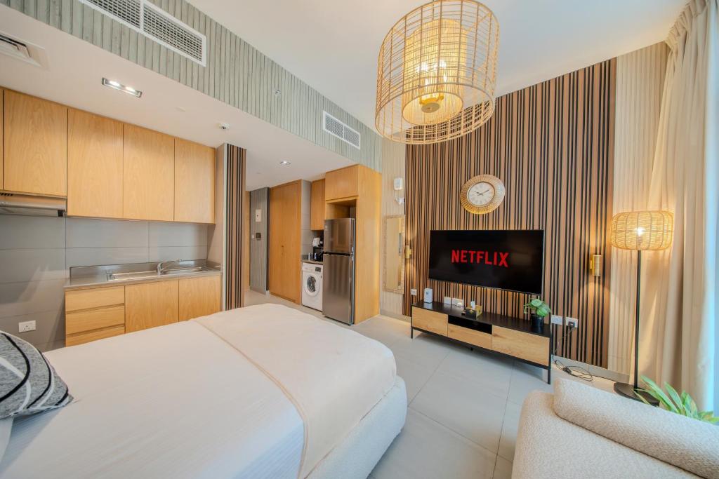 a bedroom with a king sized bed and a tv at The Boutique Studio at Al Mamsha, Sharjah in Sharjah Intl