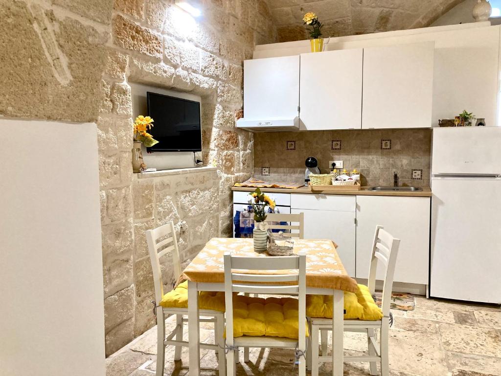 a kitchen with a table and chairs in a room at Antica Pietra in Polignano a Mare