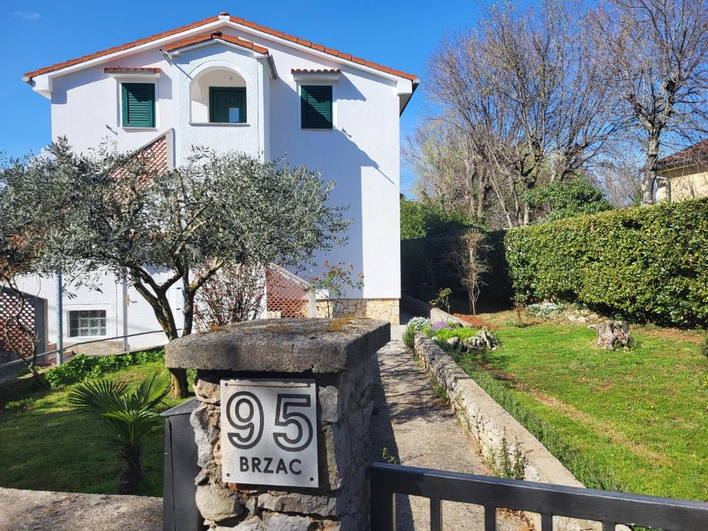 a house with a street sign in front of it at Apartmani Škrnjug in Brzac