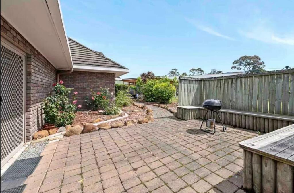 un patio trasero con una parrilla y una valla en Modern retreat- private entrance - free parking, en Kingston