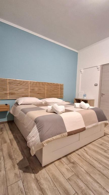 a large bed in a bedroom with a blue wall at B&B Casa Musumeci in Catania