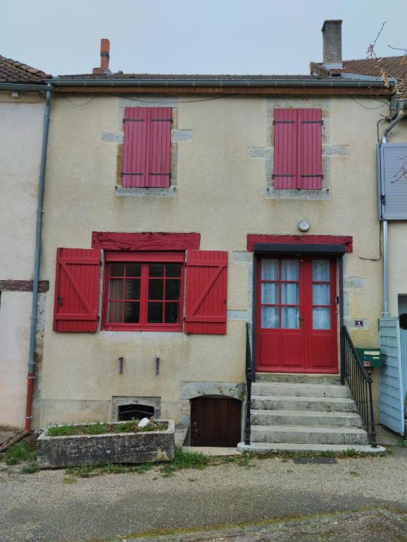 une maison ancienne avec des fenêtres et des escaliers rouges à volets dans l'établissement L'A2Milan, maison bourguignonne, à Sainte-Sabine