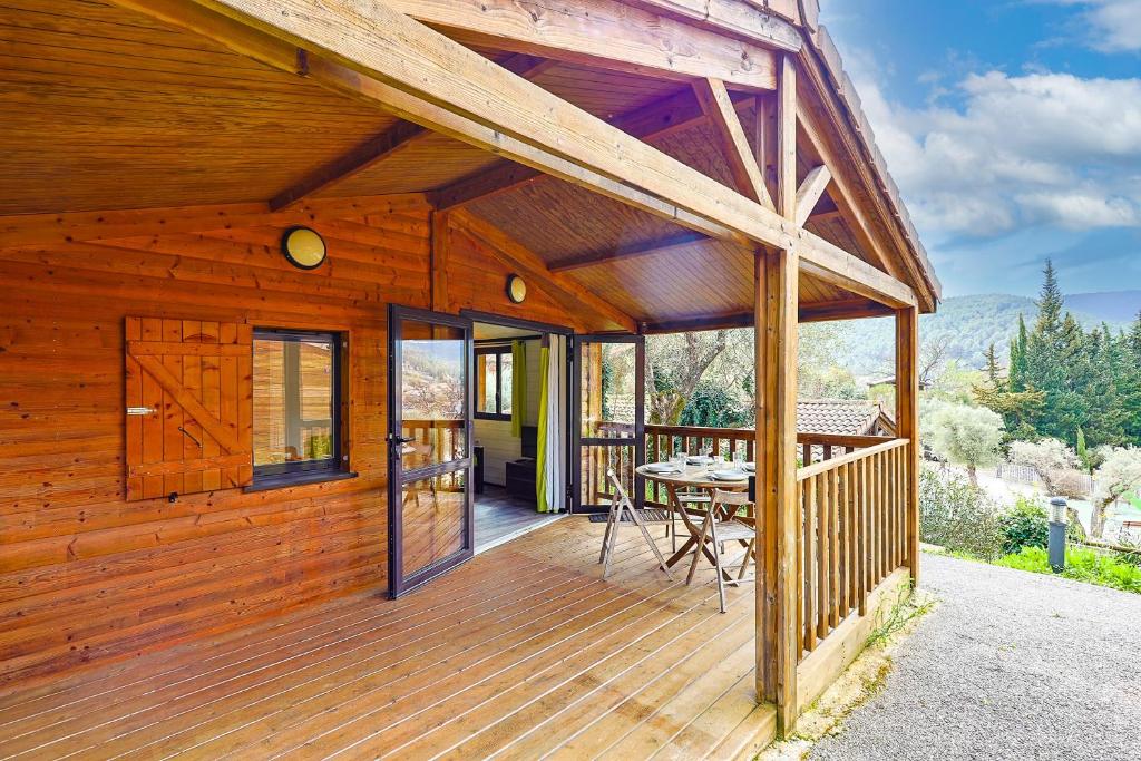 una cabina in legno con tavolo su una terrazza di Les Lingoustes - Cottage climatisé avec piscine a Solliès-Toucas