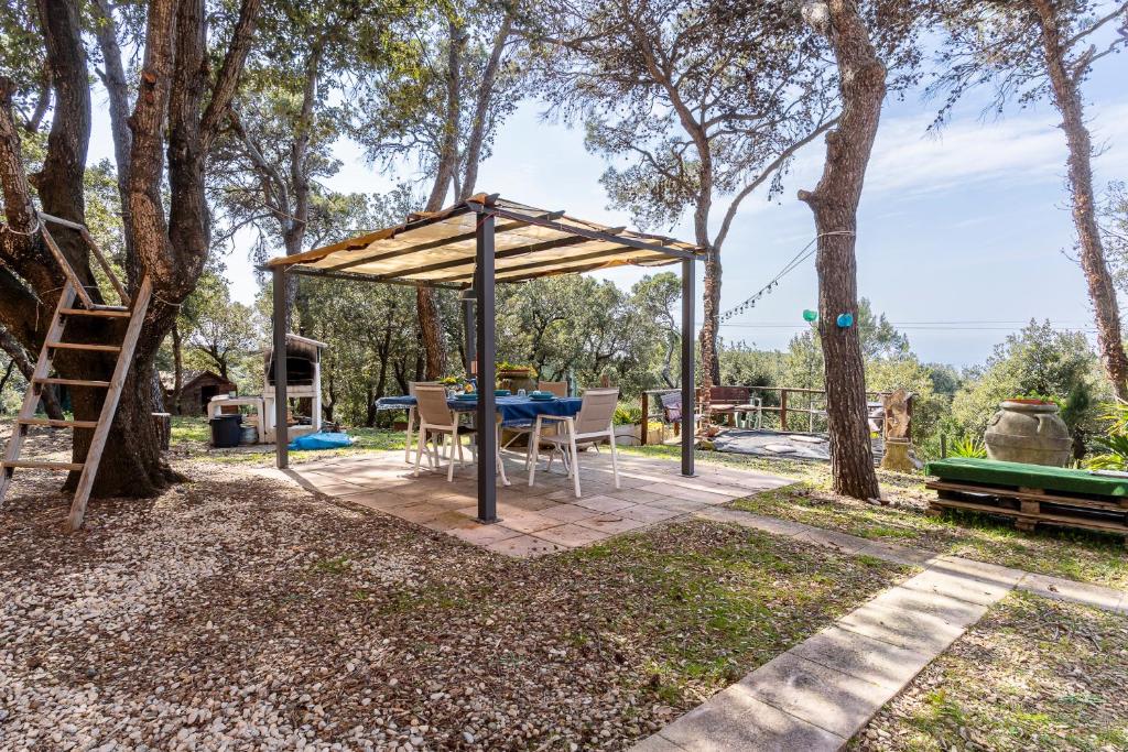 a pavilion with a table and chairs in a backyard at GuestHost - Lovely Apartment with Garden and Parking in Chioma