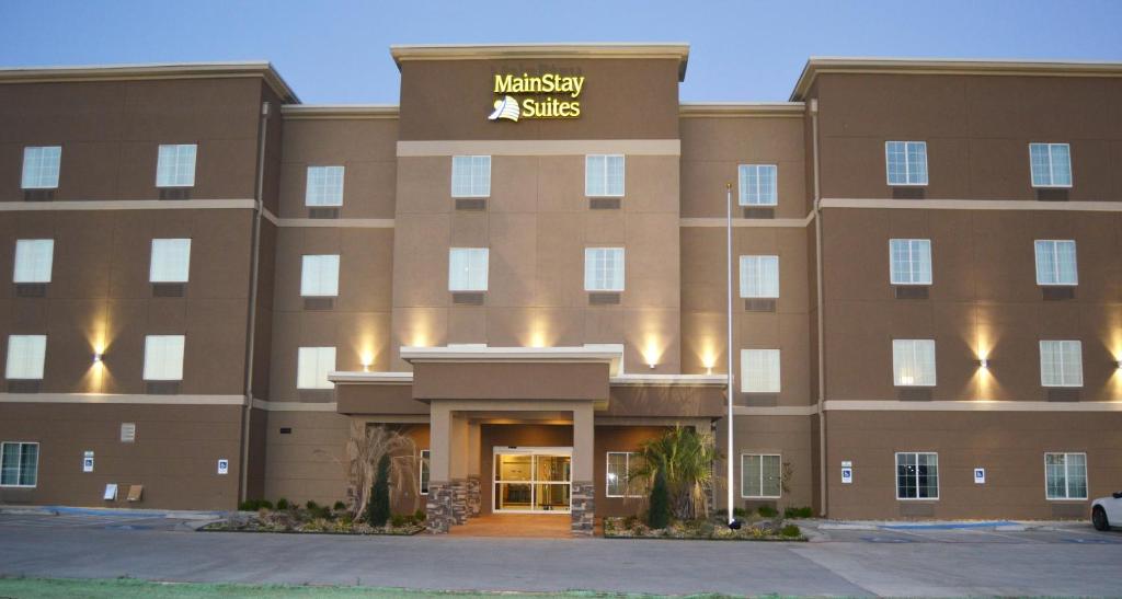 a large brown building with a sign on it at MainStay Suites Midland in Midland
