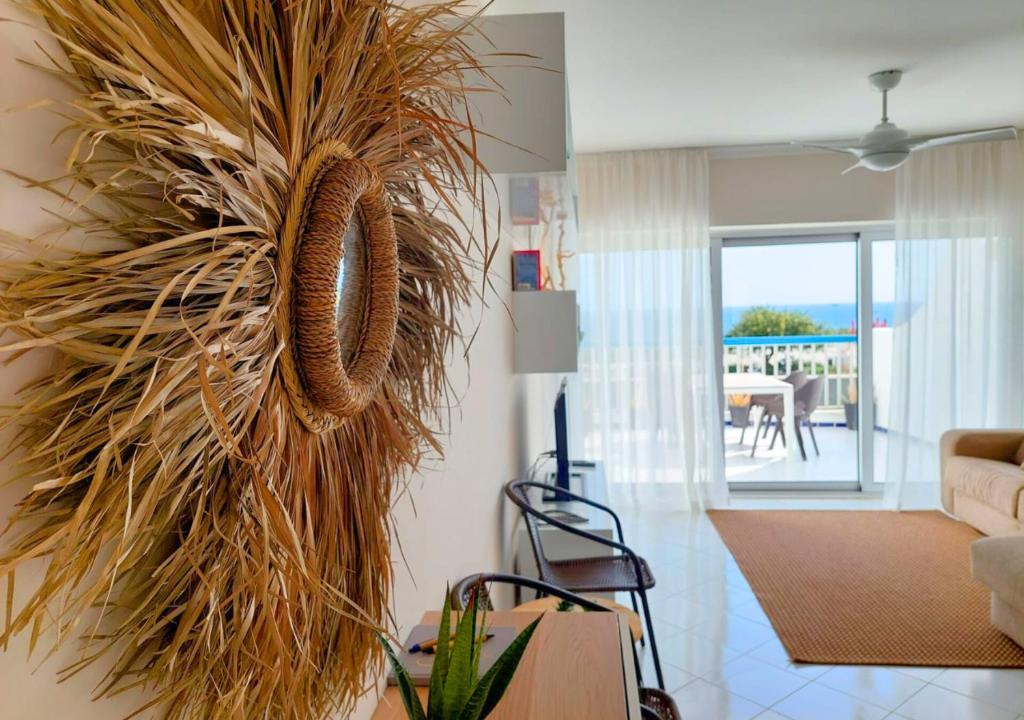 a living room with a large plant hanging on the wall at Praia da Rocha in Portimão