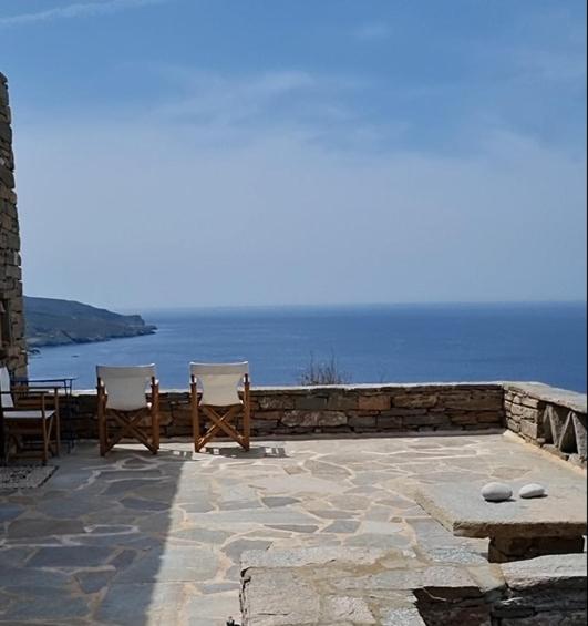 two chairs sitting on a patio overlooking the ocean at Holiday House - Koundouros Panoramic Sea View in Koundouros