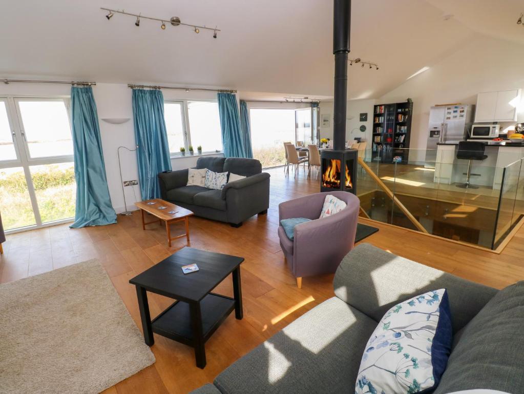 a living room with a couch and chairs and a table at Gwelfor, Marloes in Haverfordwest
