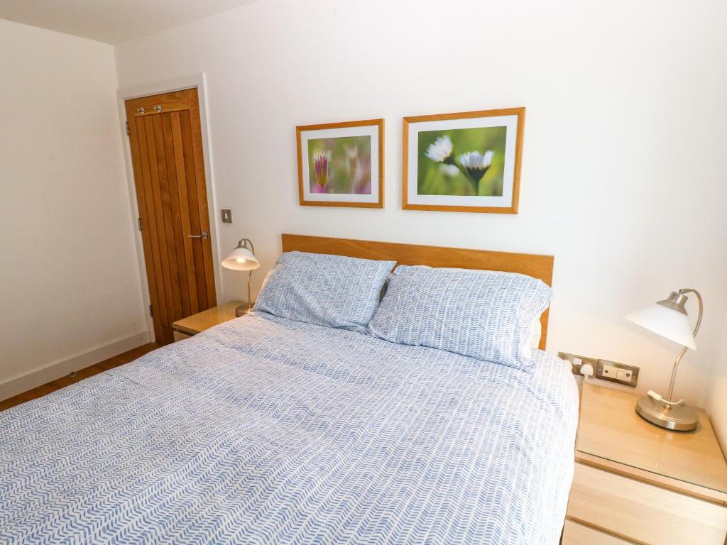 a bedroom with a bed and two pictures on the wall at Gwelfor, Marloes in Haverfordwest