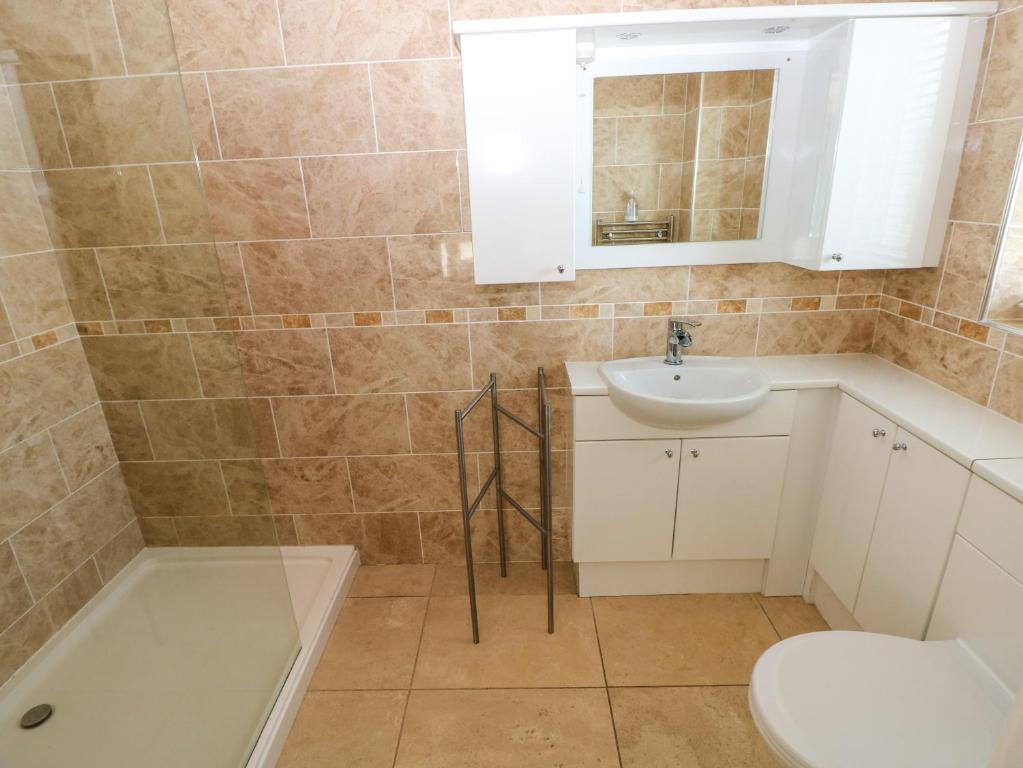 a bathroom with a sink and a toilet and a tub at Gwelfor, Marloes in Haverfordwest