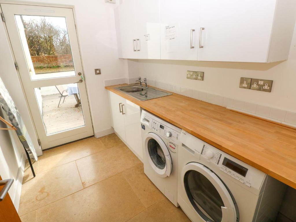 a kitchen with a washing machine and a sink at Gwelfor, Marloes in Haverfordwest
