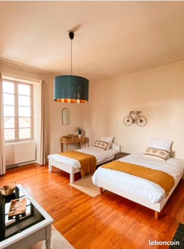 - une chambre avec 2 lits et une table dans l'établissement Jolly Château - Family and Friends suite, à Le Bernard