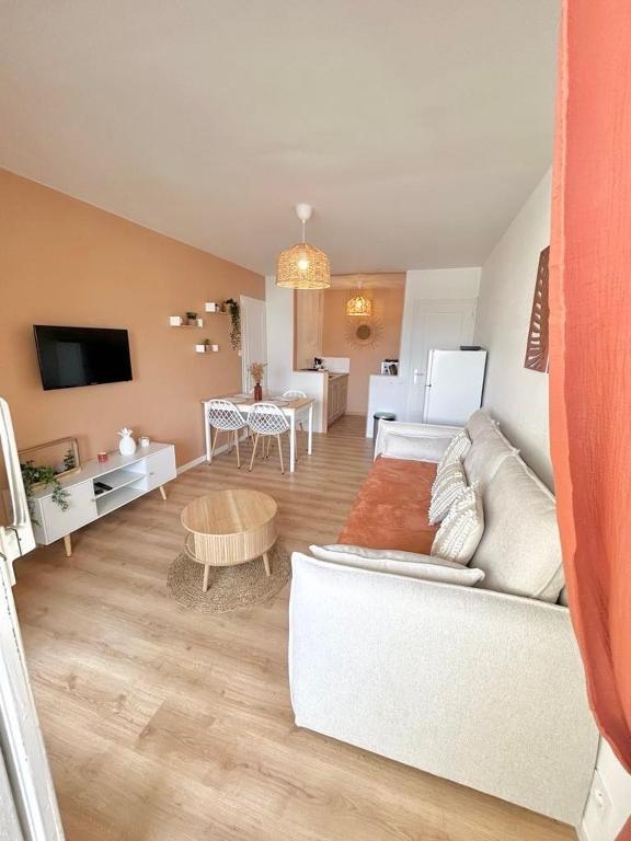 un salon avec un canapé blanc et une table dans l'établissement Le Cocon, 100m de la plage, place de parking privé, à Saint-Hilaire-de-Riez