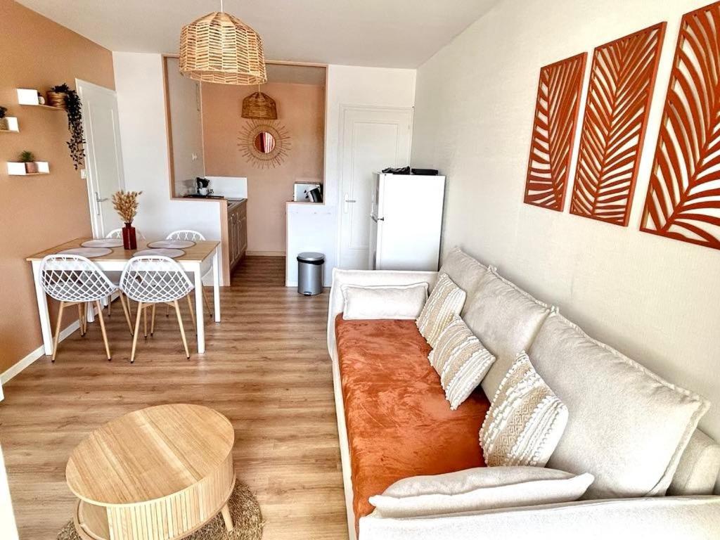 a living room with a couch and a table at Le Cocon, 100m de la plage, place de parking privé in Saint-Hilaire-de-Riez